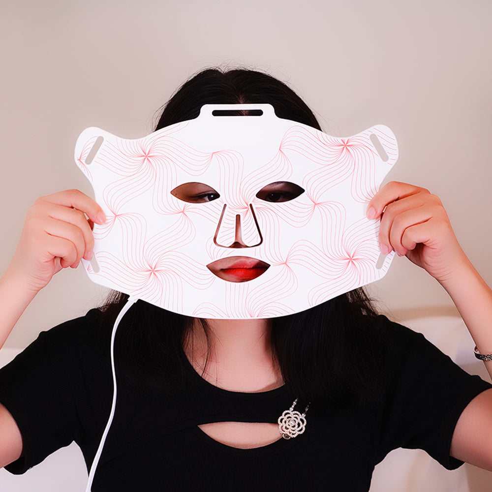 Femme utilisant un masque LED anti‑âge et de luminothérapie pour le visage à domicile, illustrant une routine beauté efficace contre les rides et le relâchement cutané.